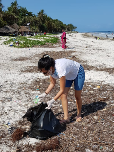 Student van het Leiden University College verzamelt plastic afval op het strand in Kenia